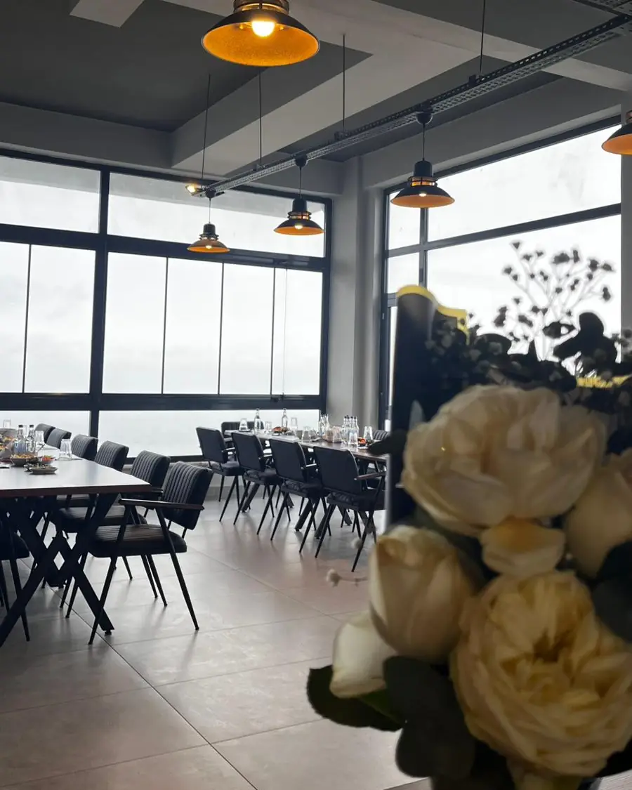 Salonun cam kenarındaki masalar ve çiçek